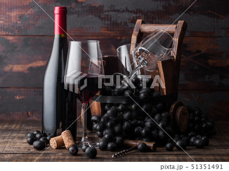 Elegant glass and bottle of red wine with grapes 51351491
