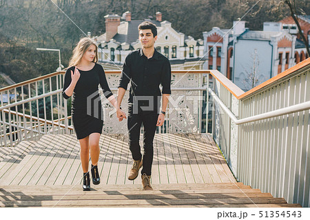 Beautiful young multiracial couple, a couple of students walk on the stairs in Kiev in the city Beautiful young multiracial couple, a couple of students walk on the stairs in Kiev in the city 51354543
