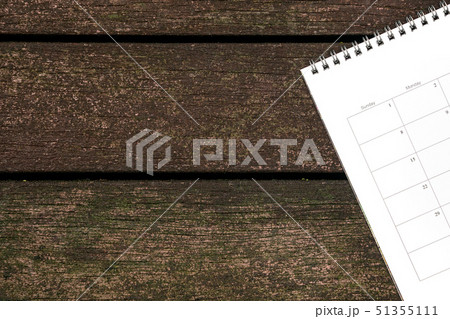 Calendar or planner on dark wood background Calendar or planner on dark wood background 51355111