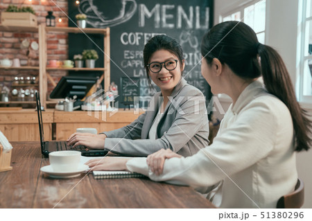 Two colleagues talking about work in cafe Two colleagues talking about work in cafe 51380296