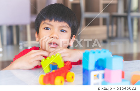 Happy boy stacking Toy blocks on a living room for 51545022