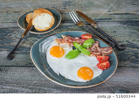 Fried eggs,  bacon, tomato, toast and butter 51600344