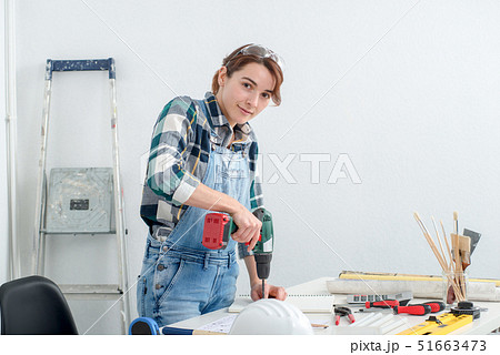 pretty young smiling woman using cordless drill pretty young smiling woman using cordless drill 51663473