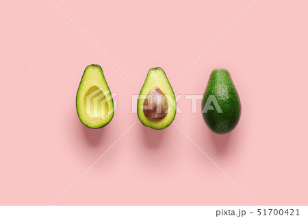 Whole avocado fruit and two halves in a row isolated on pink background 51700421