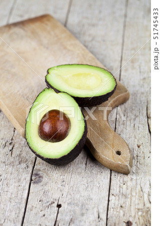 Fresh organic avocado halves on cutting board on 51745433