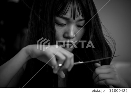 泣きながら髪を切る女性 51800422