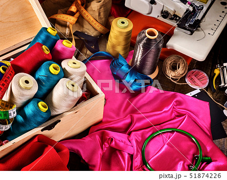 Seamstress sewing spool and embroidery hoop on coat fabric Seamstress sewing spool and embroidery hoop on coat fabric 51874226