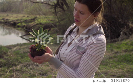 Young volunteer with the small tree in her hands 51915870