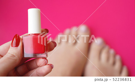 Young perfect groomed womans feet on pink background. Care about nails 52236831