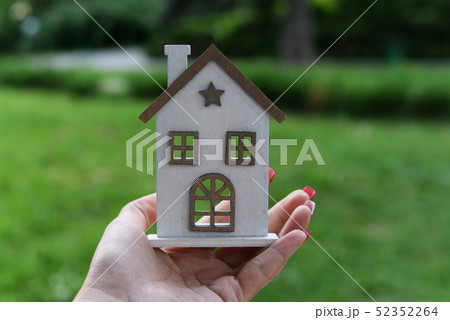 a girl is holding a wooden house building  52352264