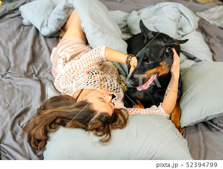 Woman in bed with big dog Woman in bed with big dog 52394799