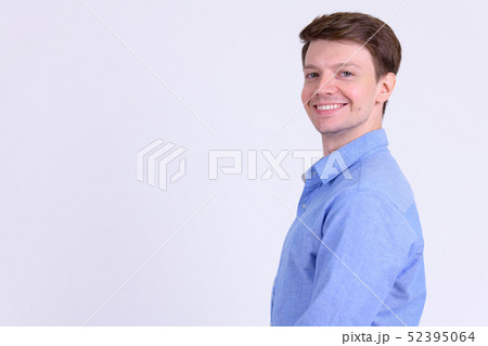 Profile view of young happy businessman smiling and looking at camera 52395064