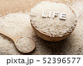 Close up view of rice in a wooden spoon and bowl 52396577