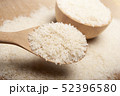 Close up view of rice in a wooden spoon and bowl 52396580