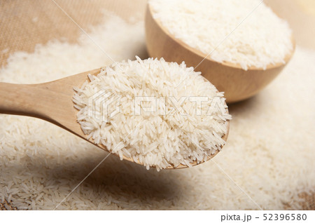 Close up view of rice in a wooden spoon and bowl 52396580