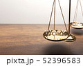 Gold brass balance scale on wooden desk 52396583