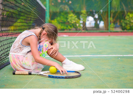 Little sad girl on tennis court 52400298