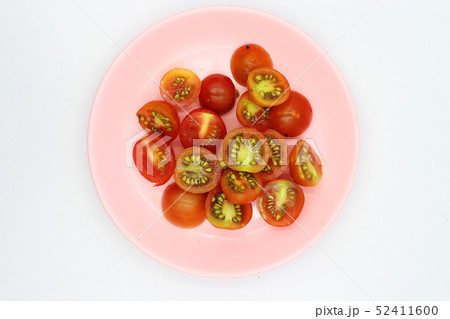 shopped tomatoes in pink dish on white background. 52411600