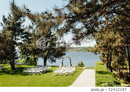 beautiful arch for the wedding ceremony in the park with white chairs for guests beautiful arch for the wedding ceremony in the park with white chairs for guests 52412197