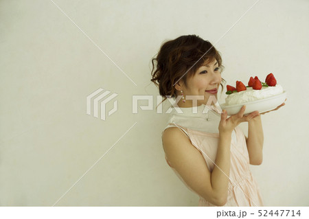 イチゴのケーキを持って微笑む女性の横顔 イチゴのケーキを持って微笑む女性の横顔 52447714