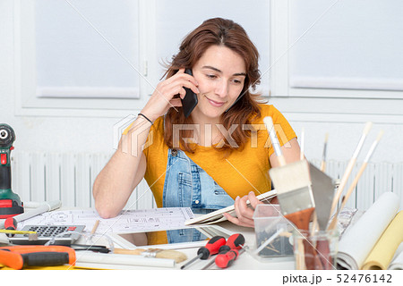 pretty young woman doing DIY talking on phone 52476142