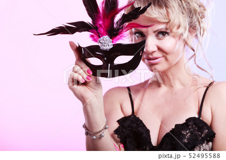 Woman middle aged holds carnival mask. 52495588