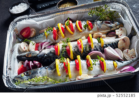 three raw mackerel in a baking pan, close up three raw mackerel in a baking pan, close up 52552185