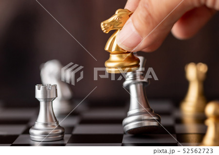 hand holding gold horse attack silver king in game 52562723