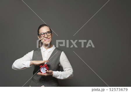 Portrait of charming businesswoman holding red vintage clock Portrait of charming businesswoman holding red vintage clock 52573679