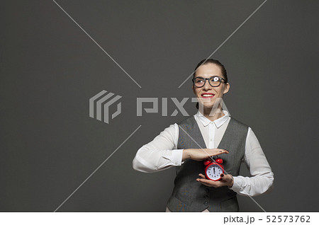 Portrait of charming businesswoman holding red vintage clock Portrait of charming businesswoman holding red vintage clock 52573762