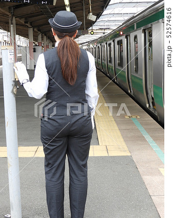 背が高い女性車掌さんの後ろ姿の写真素材