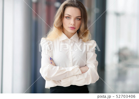 Alone wooman. Business portrait in a white blouse and a black skirt makes entries in a notebook Alone wooman. Business portrait in a white blouse and a black skirt makes entries in a notebook 52703406