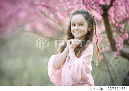 Beautiful young woman in pinkstylish garden dress blooming sakura Beautiful young woman in pinkstylish garden dress blooming sakura 52731175