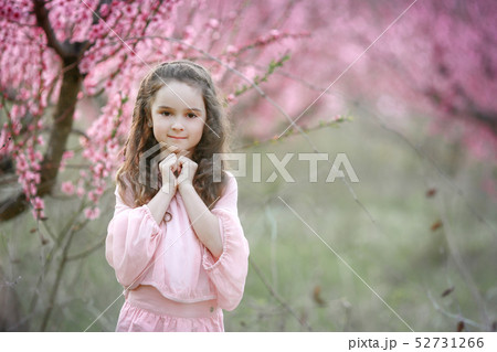 Beautiful young woman in pinkstylish garden dress blooming sakura Beautiful young woman in pinkstylish garden dress blooming sakura 52731266