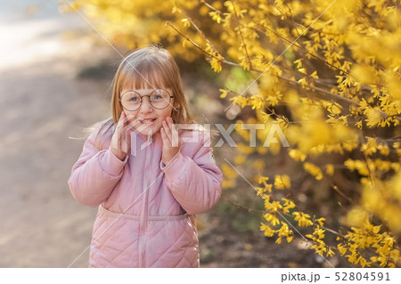 Stylish child girl 5-6 year old wearing trendy pink coat in autumn park. Looking at camera. Autumn Stylish child girl 5-6 year old wearing trendy pink coat in autumn park. Looking at camera. Autumn 52804591