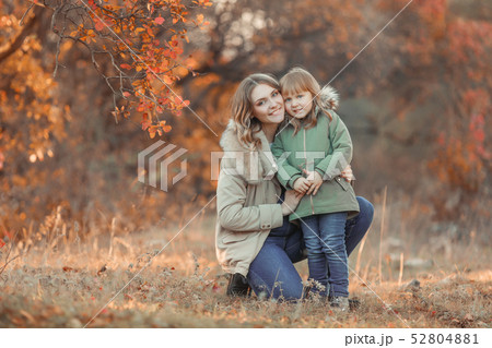 Funny kid girl pretending to be posing in autumn forest, wearing a green coat Funny kid girl pretending to be posing in autumn forest, wearing a green coat 52804881