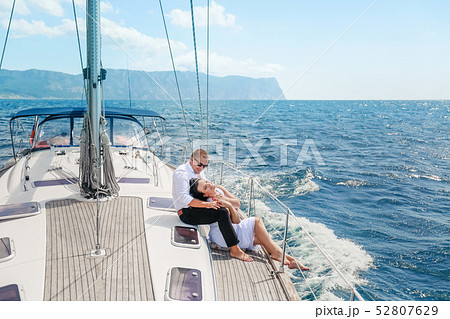 white yacht with sail set goes along the island on a hot day. blue sea, blue sky. Crimea. on board a white yacht with sail set goes along the island on a hot day. blue sea, blue sky. Crimea. on board a 52807629