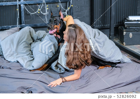 Woman in bed with big dog 52826092