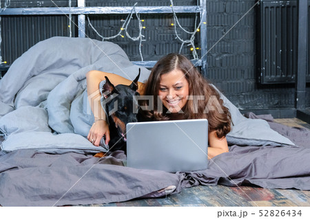 Woman in bed with big dog 52826434