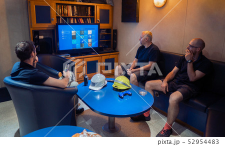 Happy team of ship officers watch TV onboard of vessel Happy team of ship officers watch TV onboard of vessel 52954483