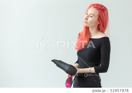 Hairdresser, beauty salon and people concept - young woman hair stylist with hair dryer on white 52957976