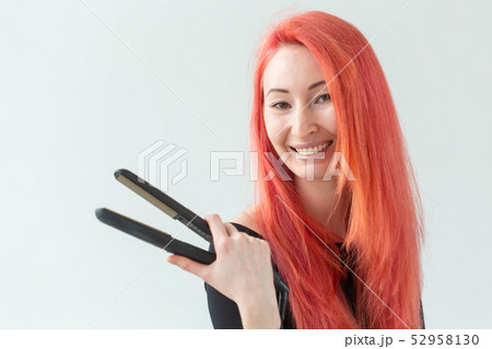 Style, fashion, hairdresser and people concept - stylish red-haired woman with curling iron on white 52958130