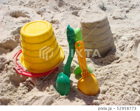 Set of color plastic children toys on sand near 52958773