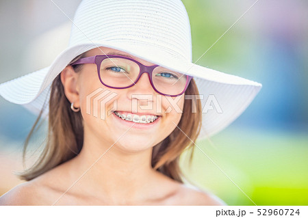 Happy smiling girl with dental braces and glasses. Happy smiling girl with dental braces and glasses. 52960724