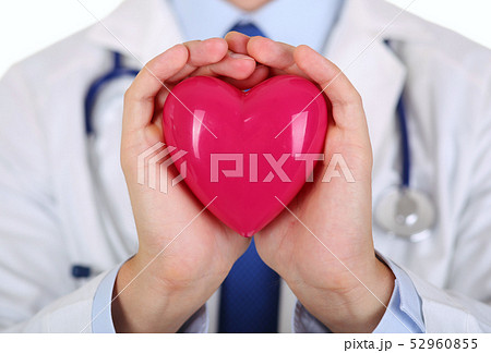 Male medicine doctor hands holding red toy heart Male medicine doctor hands holding red toy heart 52960855