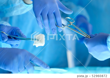 Surgeons hands holding and passing surgical instrument to other doctor Surgeons hands holding and passing surgical instrument to other doctor 52960872