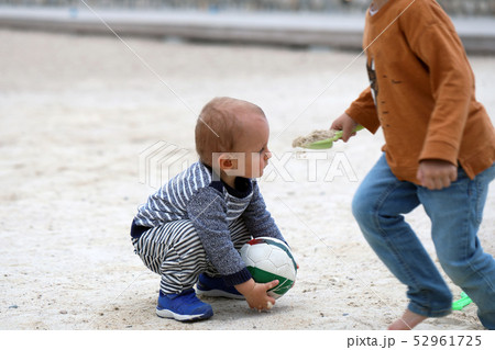 Cute Baby Playing With a Soccer Ball on Sand Cute Baby Playing With a Soccer Ball on Sand 52961725