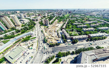 Aerial city view with crossroads and roads, houses, buildings, parks and parking lots. Sunny summer Aerial city view with crossroads and roads, houses, buildings, parks and parking lots. Sunny summer 52967335