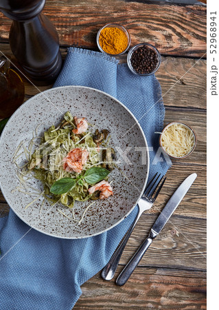 Tagliatelle with shrimp. Homemade pasta with basil sauce and shrimps and parmizan cheese. Wooden Tagliatelle with shrimp. Homemade pasta with basil sauce and shrimps and parmizan cheese. Wooden 52968941