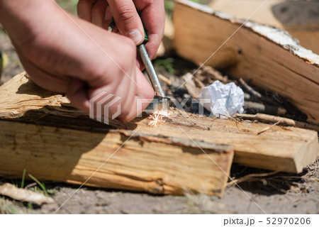 A pair of hands making a fire with flint and steel A pair of hands making a fire with flint and steel 52970206